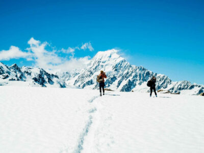 Travelers walking in snowy mountains.
